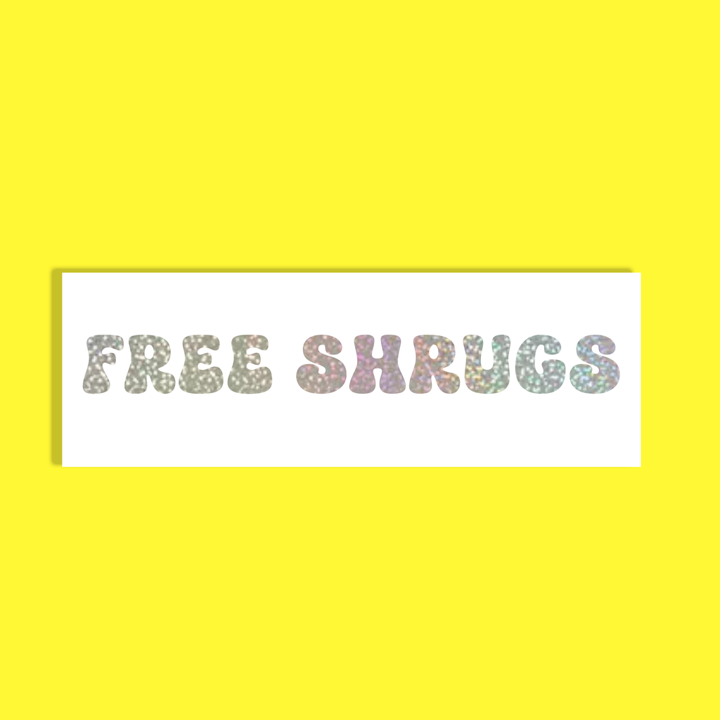 A white rectangular card with the words 'FREE SHRUGS' in large, pastel glitter-style letters, centered on a bright yellow background.