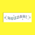 A rectangular white background featuring the word 'HUZZAH!' in silver glittery, holographic  letters with small star accents, set against a solid bright yellow background.