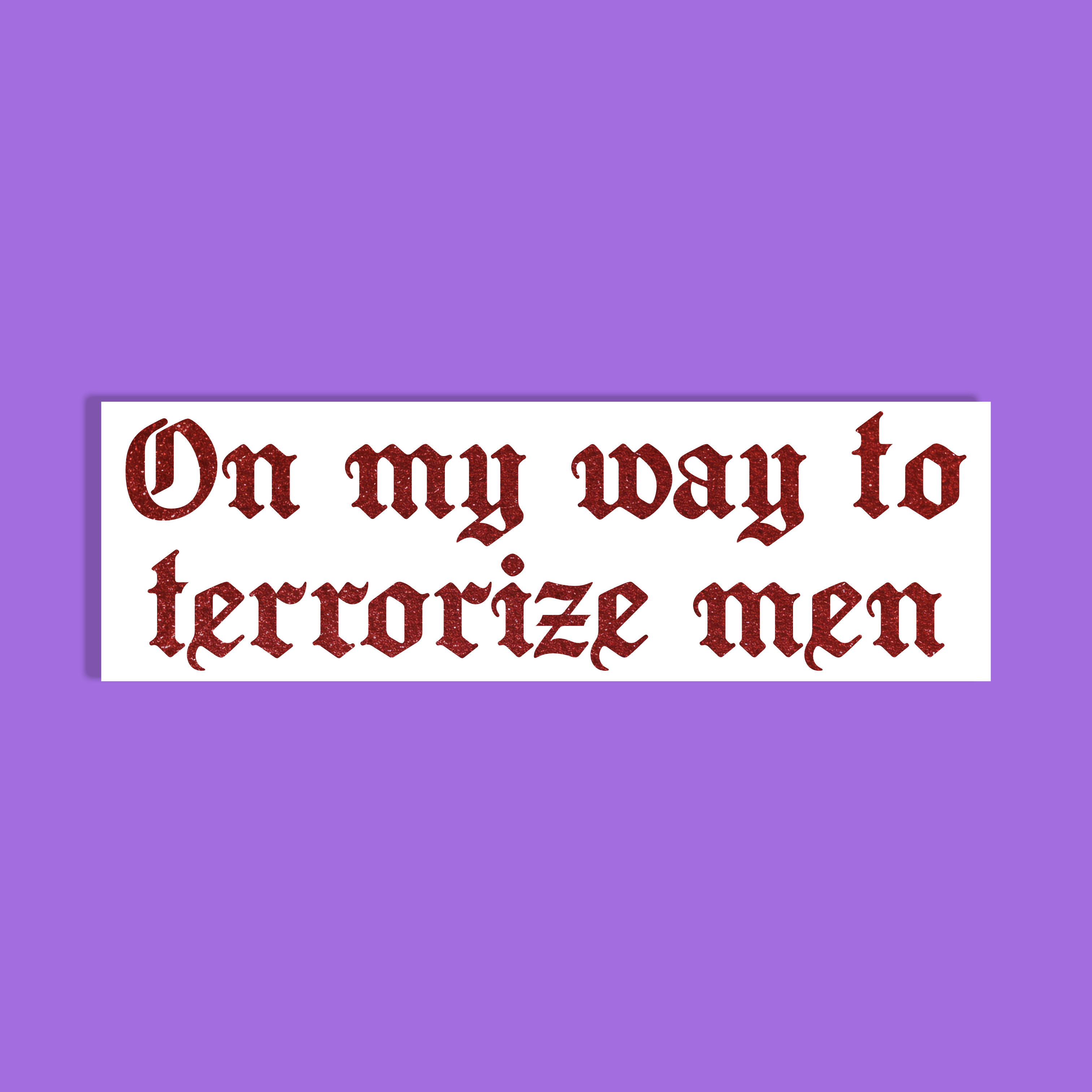 A rectangle with the phrase 'On my way to terrorize men' in a dark red glittery Gothic-style font on a white background, shown against a solid purple backdrop.