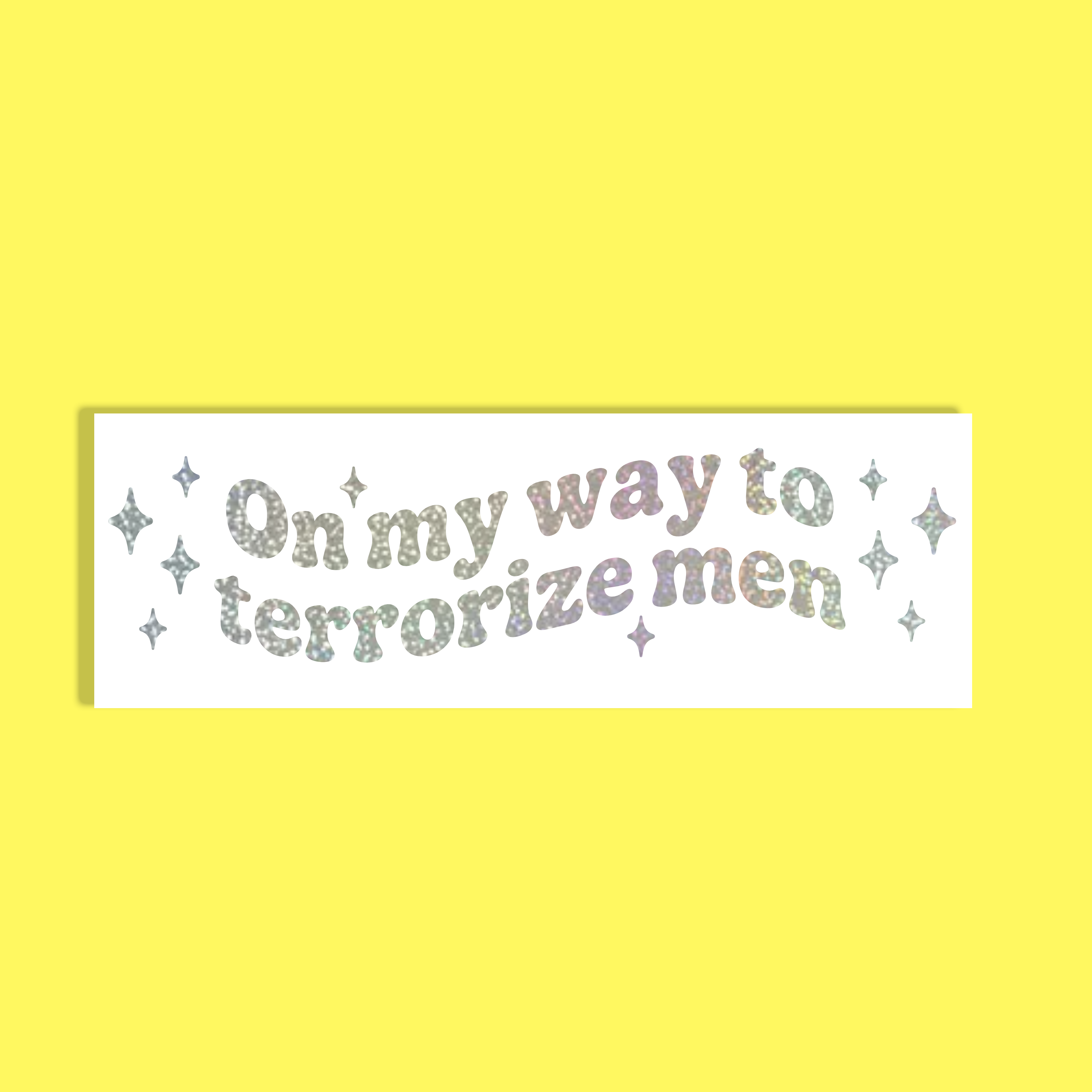 A rectangular white background with the phrase 'On my way to terrorize men' in glittery pastel lettering, surrounded by small glittery stars, shown on a solid bright yellow background.