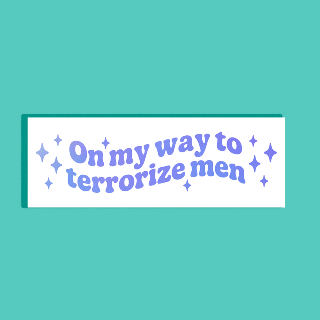 A white rectangular background, featuring the phrase 'On my way to terrorize men' in holographic blue and purple retro-style lettering with small holographic blue and purple stars, shown on a solid teal background.