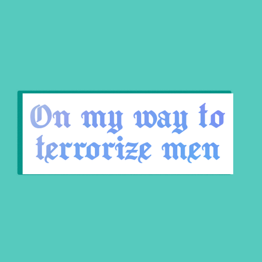 A rectangular white background with the text 'On my way to terrorize men' in a light blue gothic font on a white background, shown against a solid teal backdrop.