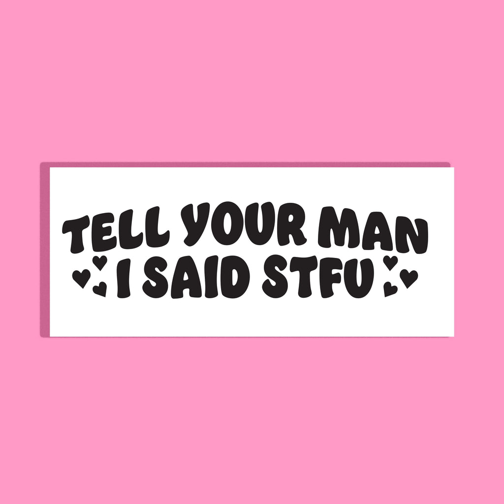 A rectangular white background with black text reading 'TELL YOUR MAN I SAID STFU' and small heart accents, centered on a solid pink background.