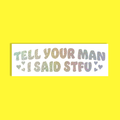 A rectangular white sticker with the phrase 'TELL YOUR MAN I SAID STFU' in glittery, pastel gradient letters, displayed on a solid bright yellow background.