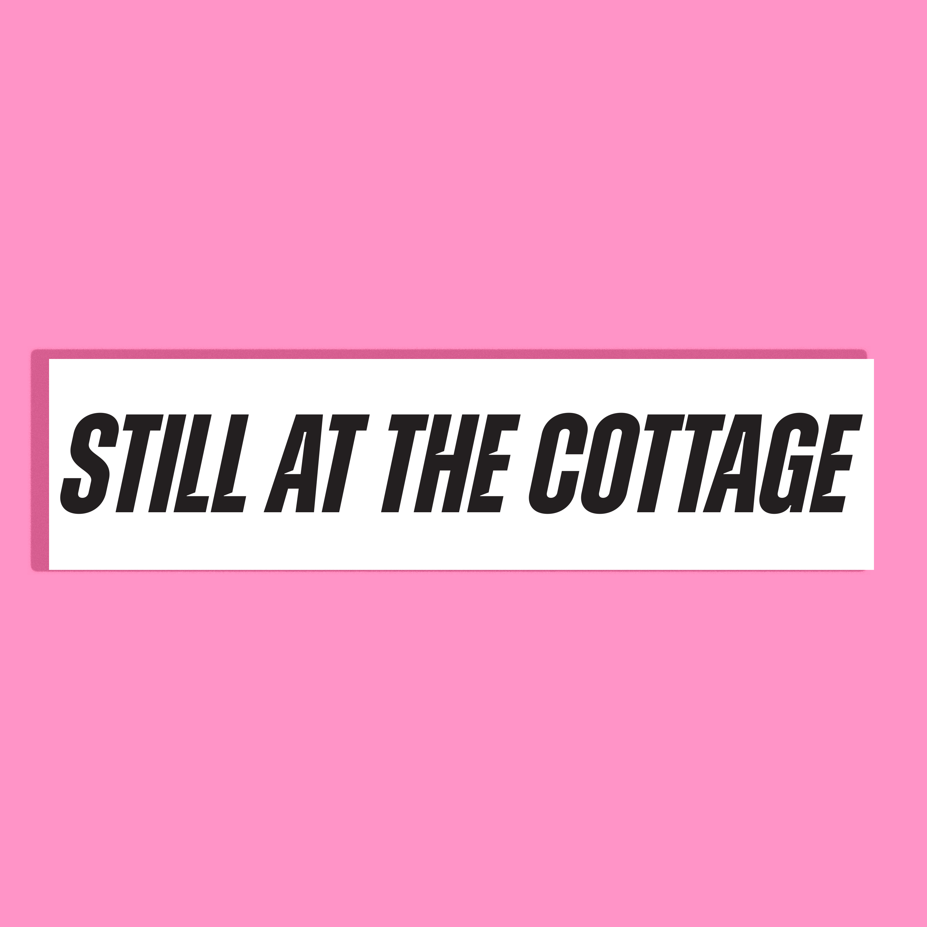 A rectangular white background with the phrase 'STILL AT THE COTTAGE' in bold black lettering, centered on a solid pink background.