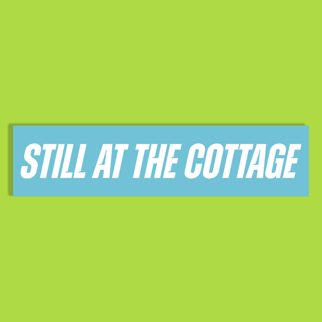 The text 'STILL AT THE COTTAGE' in white bold letters on a light blue background, shown against a solid lime green backdrop.