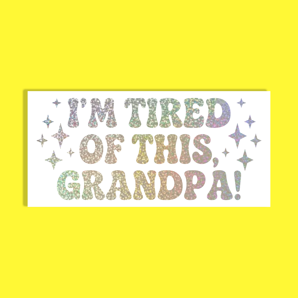 A rectangular white background with the phrase “I'M TIRED OF THIS, GRANDPA!” in glittery multicolor letters, surrounded by small glittery stars, shown on a solid bright yellow background.